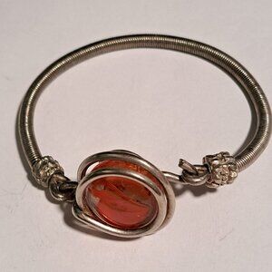 silver color bracelet with orange glass stone design